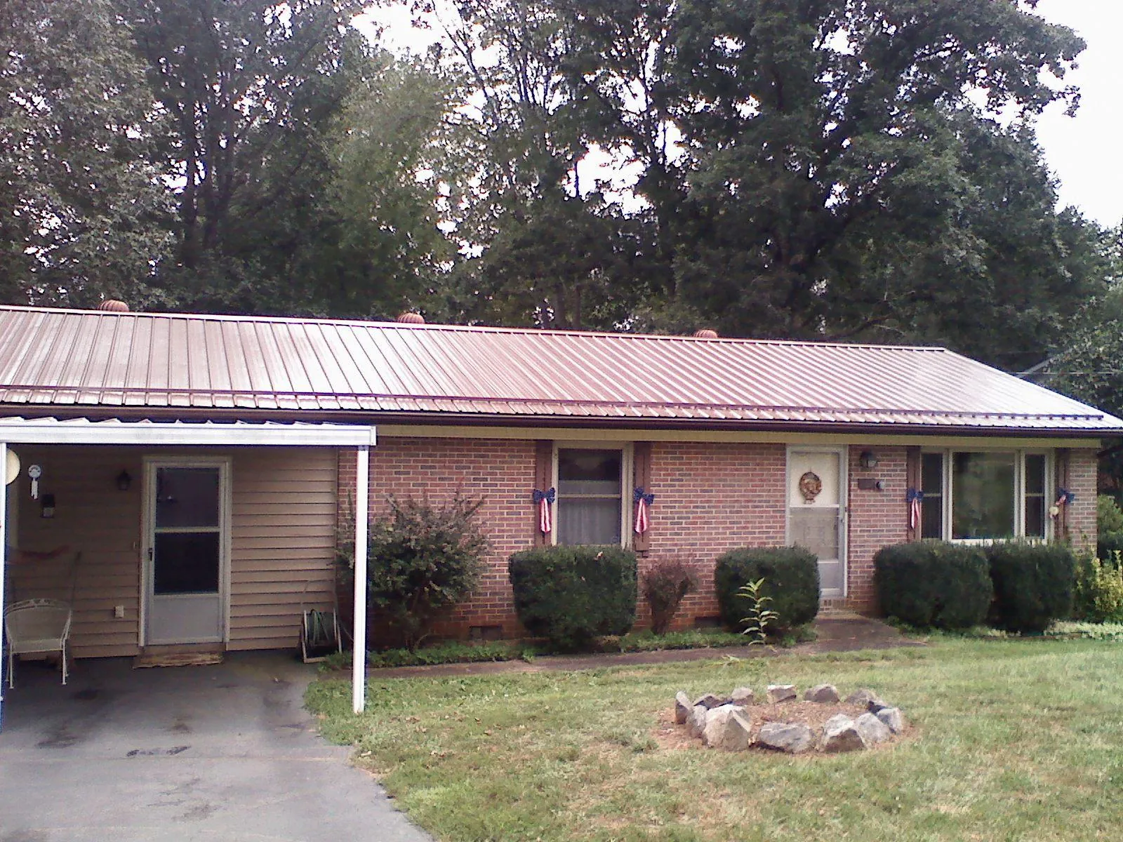 Bronze metal roof and carport on a brick ranch home — Roof Repair work by our crew in Hartford